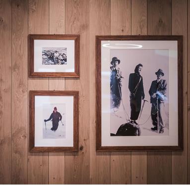 Framed photographies from the past on a wooden wall
