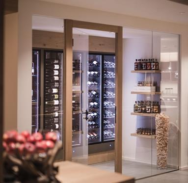 Shelves with wine bottles behind a glass door