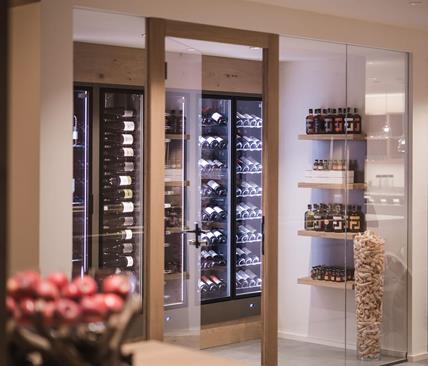 Scaffali con bottiglie di vino dietro ad una porta di vetro