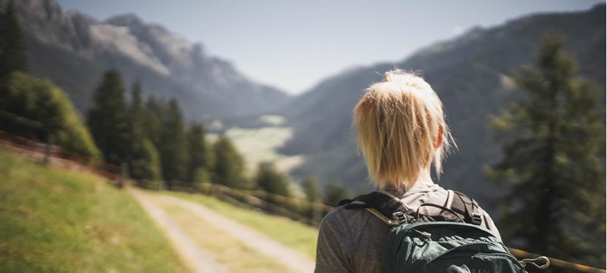 Eine Frau beim Wandern im Sommer von hinten