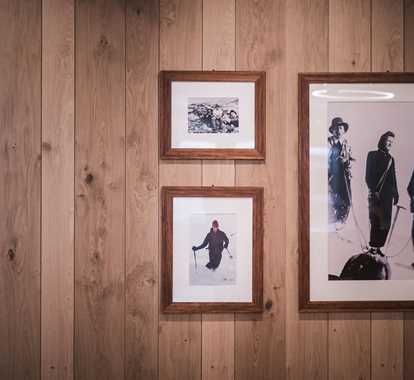 Framed photographies from the past on a wooden wall
